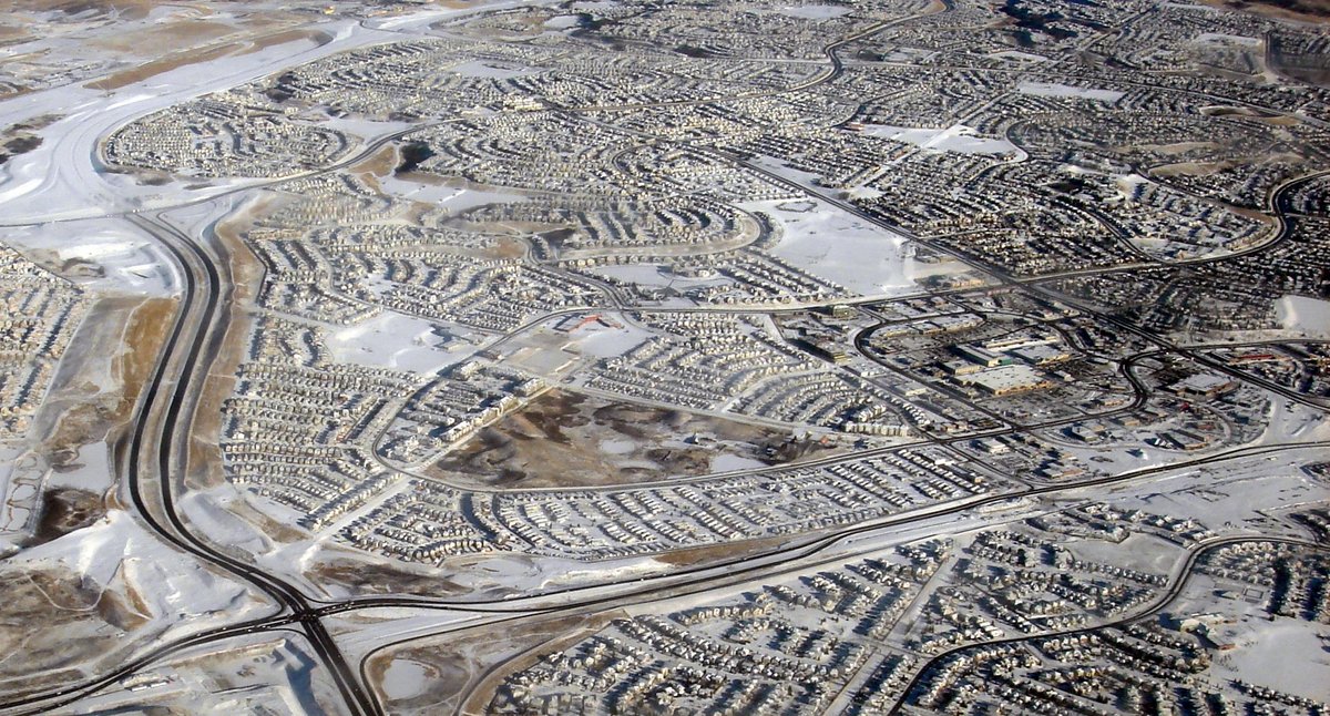 Winter aerial view of Arbour Lake with homes, the frozen lake and surrounding roads.