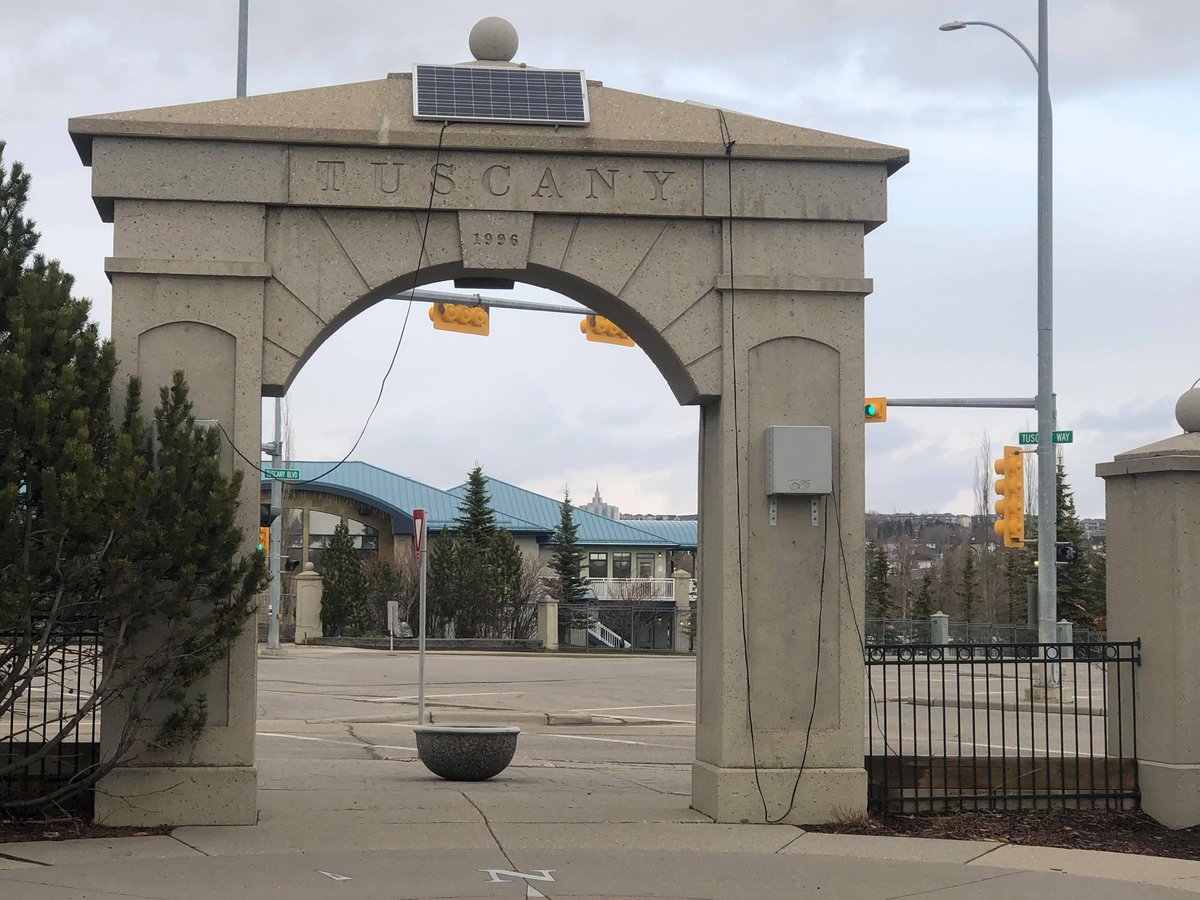 The stone Tuscany entrance arch beside traffic lights in northwest Calgary.